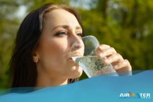 Immagine di una donna che beve acqua frizzante con soddisfazione